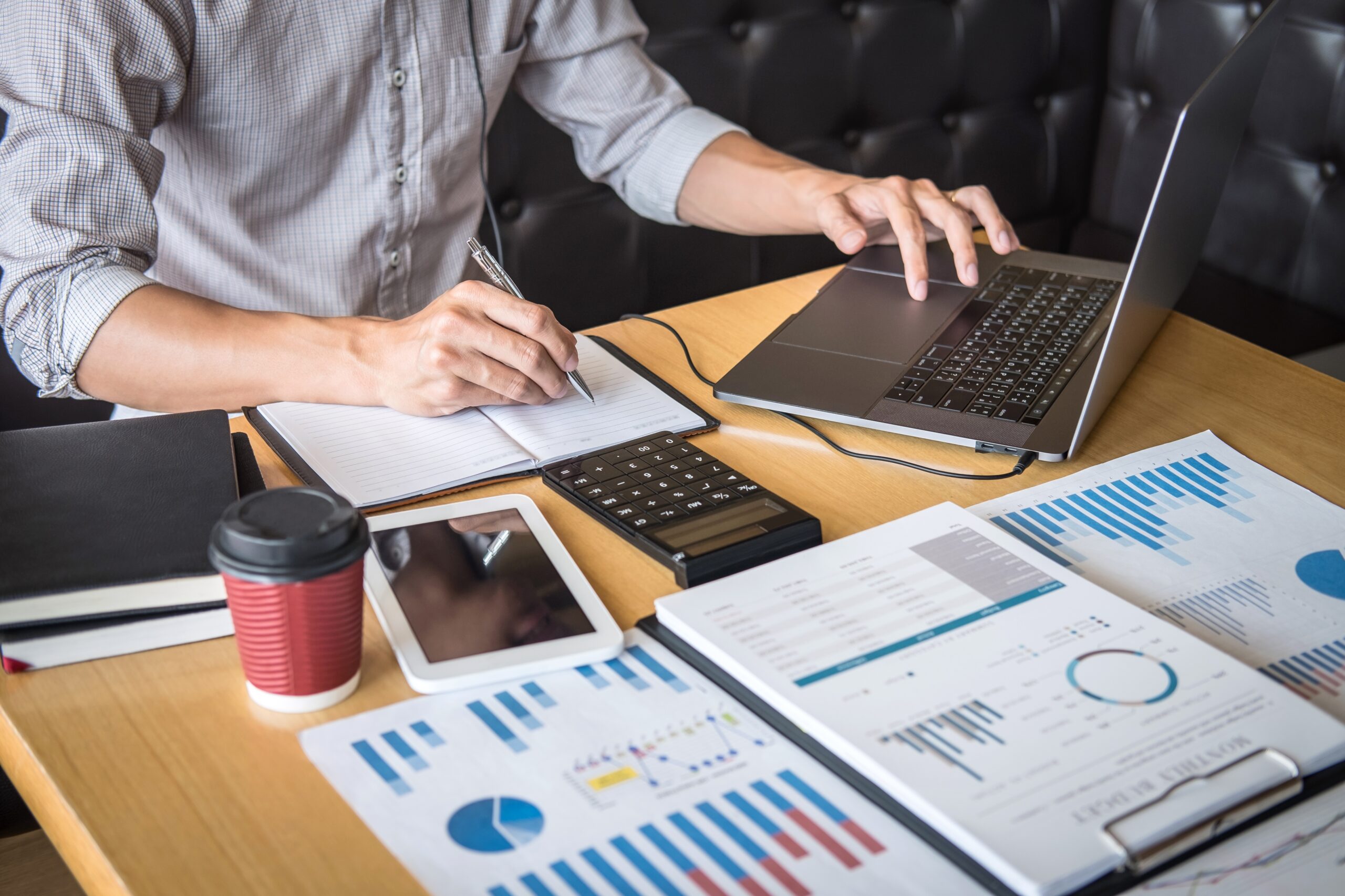 Businessman accountant working audit and calculating expense financial annual financial report balance sheet statement, doing finance making notes on paper checking document.